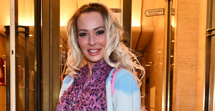 Cora Schumcher mit offenen blonden Haaren und einem Leoparden-Schal.