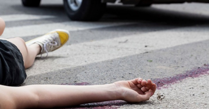 Ein Frau liegt nach einem Unfall auf der Straße.
