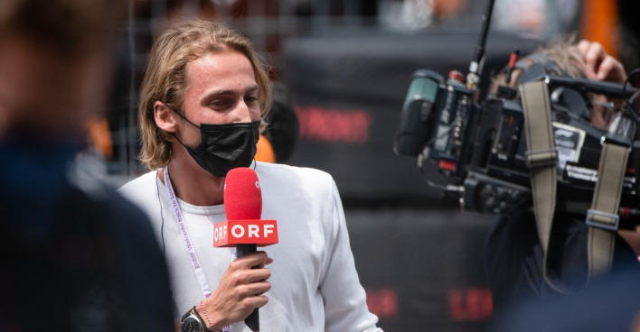 Ferdinand Habsburg mit einer FFP2-Maske und ORF-Mikrofon vor einer Kamera
