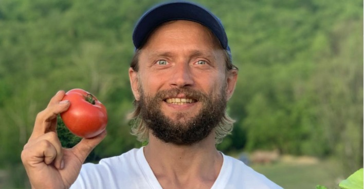 "Influencer" Maxim Lyutyi lächelnd und mit einer Tomate in der Hand.