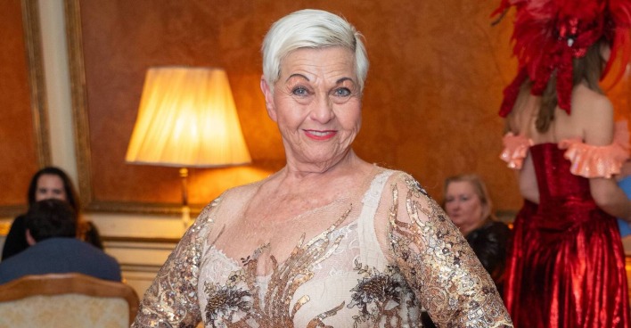 Jazz Gitti in einem goldenen Kleid mit kurzen blondierten Haaren.