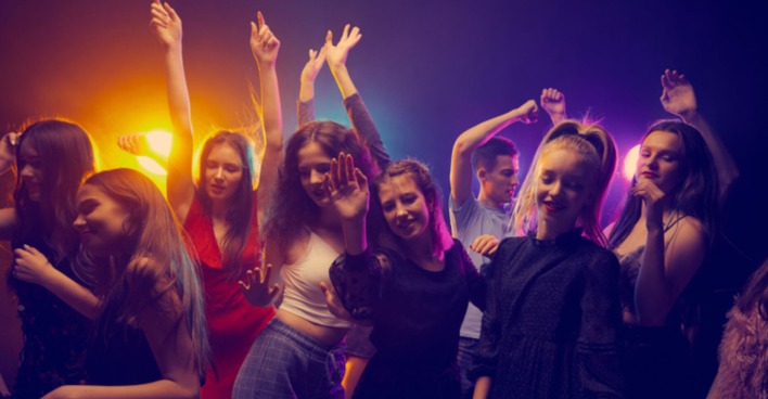 Mehrere junge Menschen tanzen in einem Club