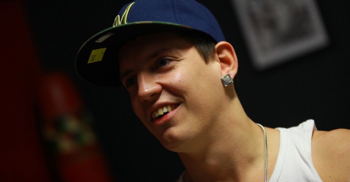 Money Boy mit einer Kappe und einem weißen Trägershirt.