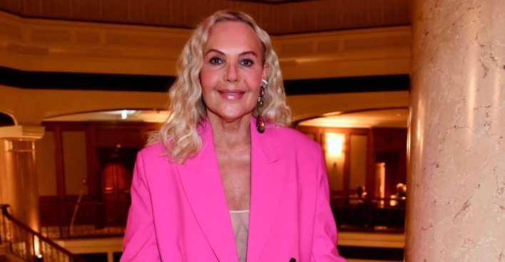 Natascha Ochsenknecht mit einem pinken Outfit und offenen blonden gewellten Haaren.