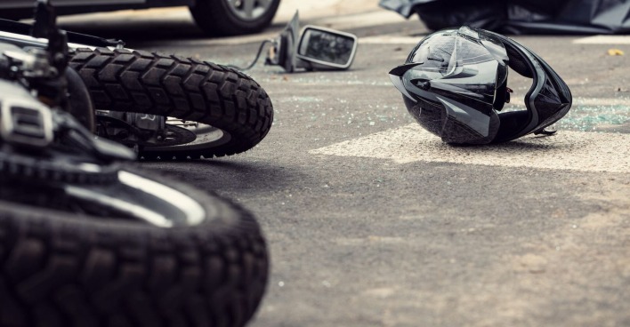 Ein Motorrad und ein Helm liegen nach einem Unfall auf der Straße.