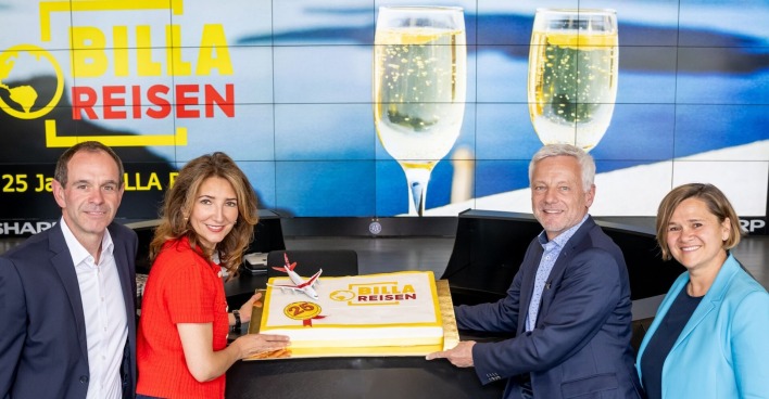 Jeweils zwei Personen links und rechts neben einer großen Torte