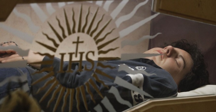 Carlo Acutis nach seinem Tod, friedvoll in einem gläsernen Sarg liegend
