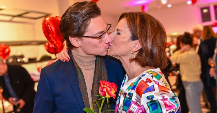 Claudia Obert küsst ihren Partner Max Suhr und hält eine Rose in der Hand.