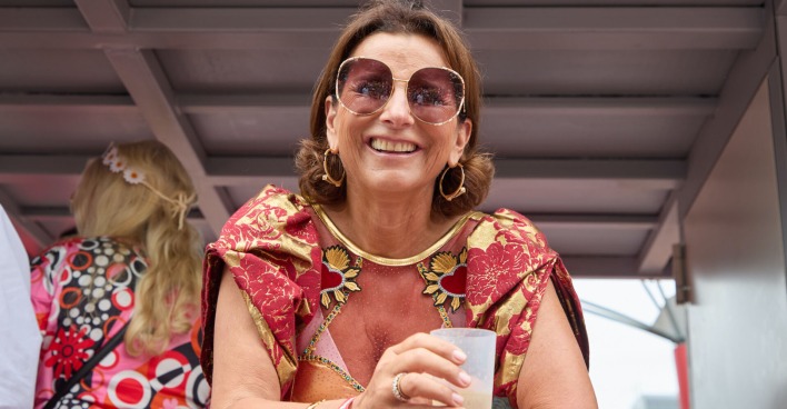 Claudia Obert mit einem Drink und einer Sonnenbrille.