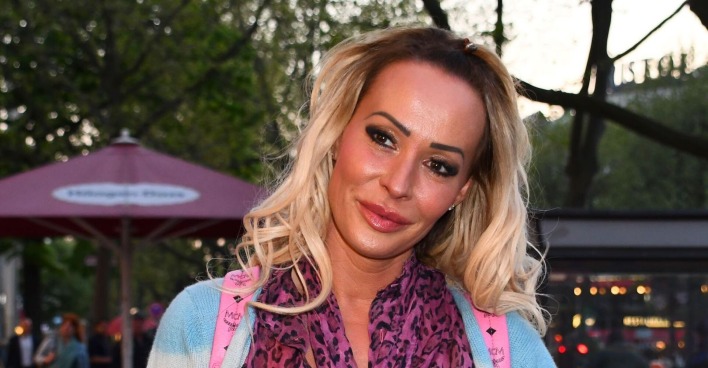 Cora Schumacher mit offenem, gewelltem, blondem Haar und Leopardenschaal.