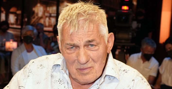 Heinz Hoenig mit einem weißen Hemd und kurzen Haaren.