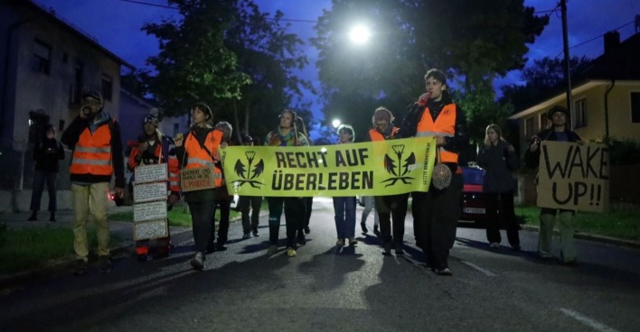 Klimaaktivisten marschieren brüllend durch Wiens Straßen.