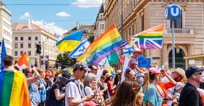 Menschen mit Flaggen bei der Vienna Pride 2022 in Wien