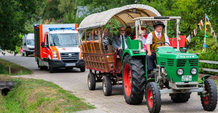 Traktorausfahrt mit Anhänger, dahinter ein Rettungswagen.
