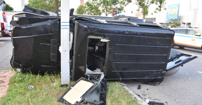 Schwarzer Unfallwagen kracht gegen Lichtmast.