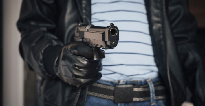 Ein Räuber mit einer Waffe in der Hand.