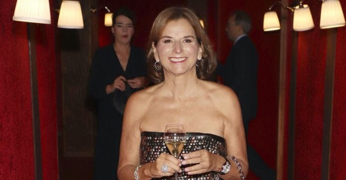 Claudia Obert mit ienem Champagner Glas und einem schulterfreien Kleid.