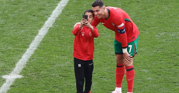 Ein Fußballspieler macht gemeinsam mit einem Fan ein Selfie