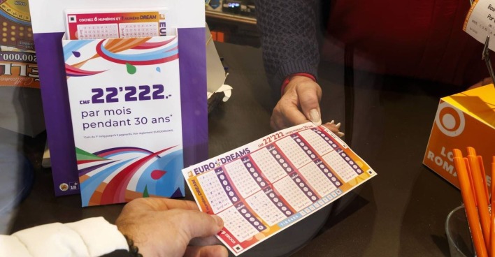 Jemand gibt einen ausgefüllten EuroDreams-Tippschein ab.
