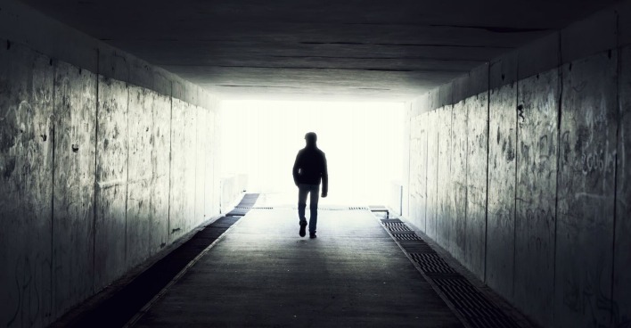 Ein Mann in einem Tunnel von hinten.
