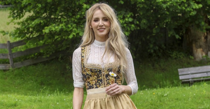 Melissa Naschenweng mit blonden offenen Haaren und einem Dirndl.