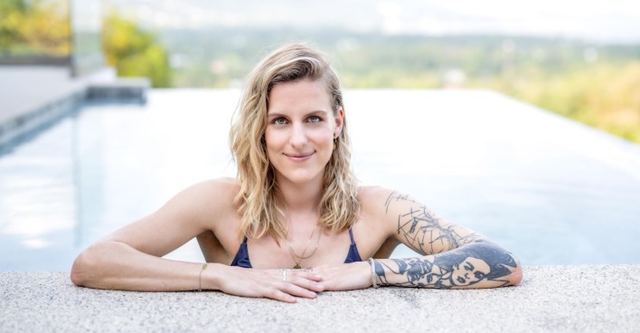 Die neue Princess Charming mit offenen blonden Haaren und einem Tattoo am Arm im Pool.