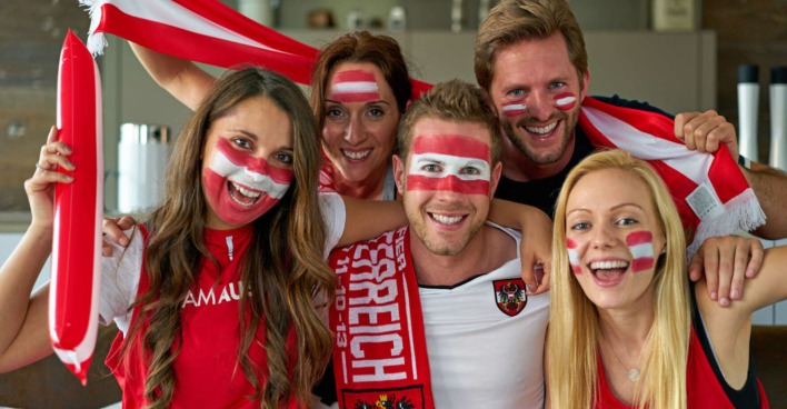 Mehrere österreichische Fußball-Fans schauen sich ein Spiel an