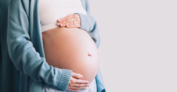 Schwangere Frau, die ihren Bauch hält
