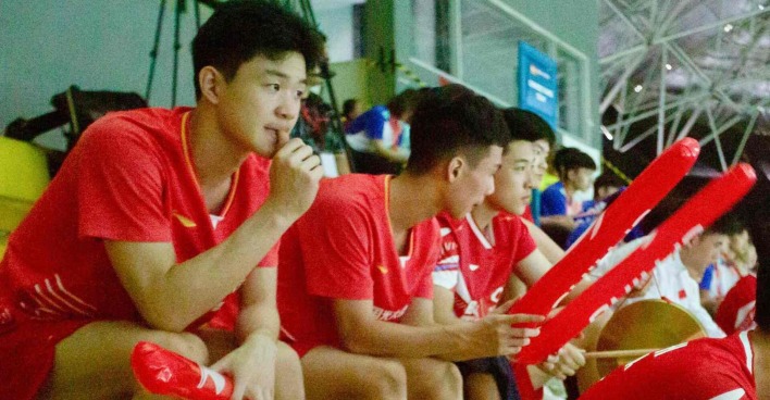 Chinesische Badmintonspielerinnen und -spieler beobachten und unterstützen ihre Mannschaftskameradinnen und -kameraden von der Tribüne aus bei den Junioren-Asienmeisterschaften 2024 in Yogyakarta.