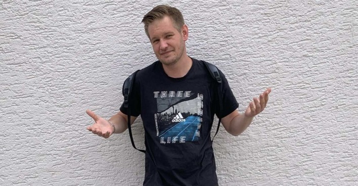 Falko Ochsenknecht steht vor einer Mauer.