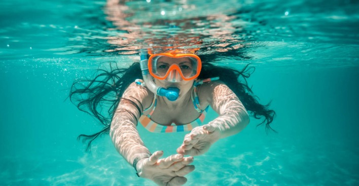 Eine Frau schnorchelt im blauen Meer