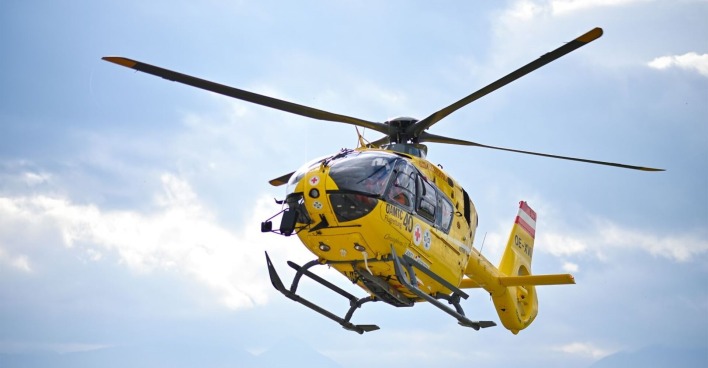 Ein gelber ÖAMTC-Rettungshubschrauber in der Luft.