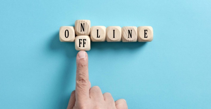 Finger der den Buchstaben N vom Wort Online wegschiebt mit einem Doppel-F Stein, damit das Wort offline ergibt