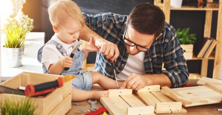 Vater bastelt mit seinem Kleinkind an einem DYI-Projekt