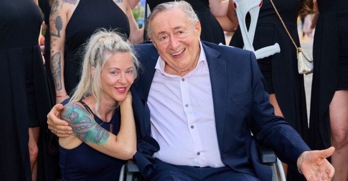 Richard Lugner im Rohlstuhl mit Simone.