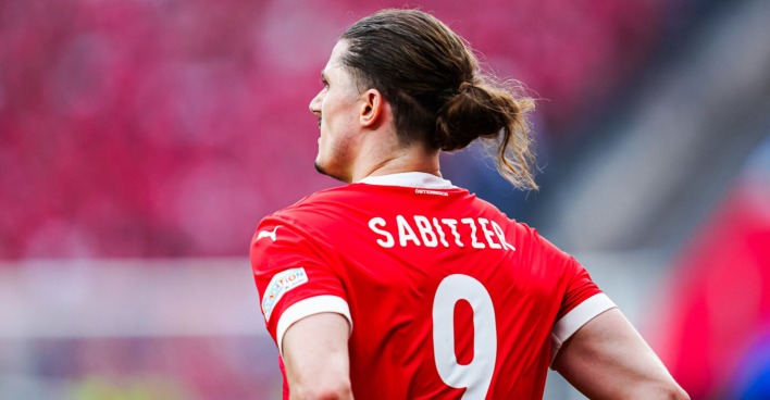 Ein Fußballspieler steht mit dem Rücken zur Kamera am Feld