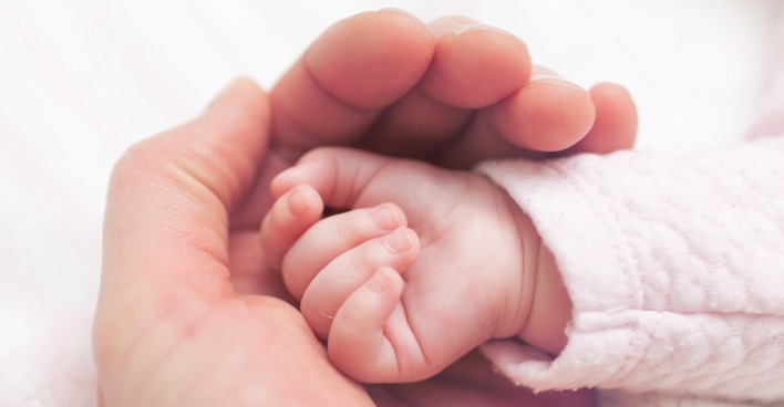 Babyhand in Hand der Mutter