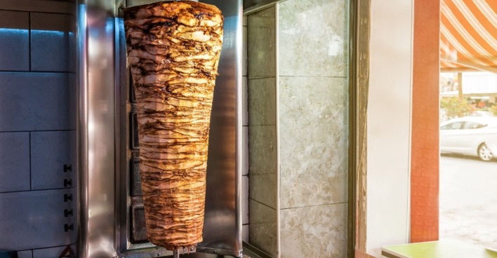 Dönerspieß gebraten auf Drehspieß in einer Kebapbude