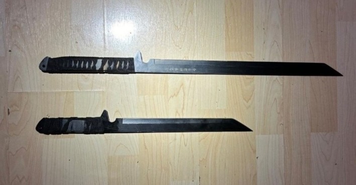 Zwei Macheten auf Holztisch liegend