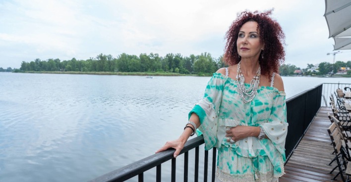 Frau starrt an einem See in die Ferne
