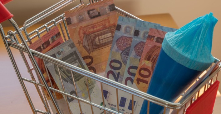 Einkaufswagen mit Geldscheinen und Schultüte gefüllt