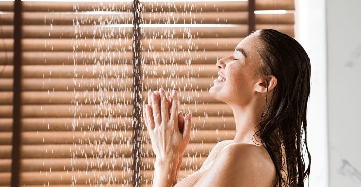 Frau steht in einer Spa-Dusche | Credit: iStock.com/Prostock-Studio