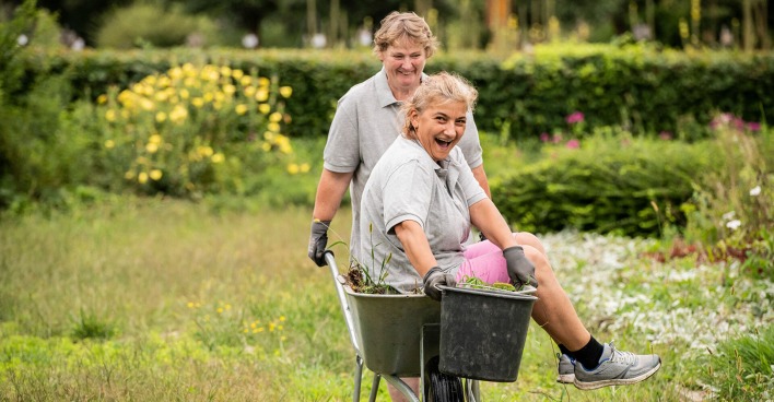 Frau führt eine andere im Schubkarren durch den Garten | Credit: Miriam Raneburger