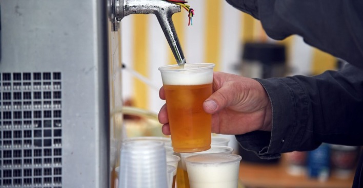 Zapfanlage, an der Bier in einen Becher eingefüllt wird