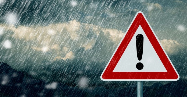 Warnschild und starker Regen im Hintergrund.