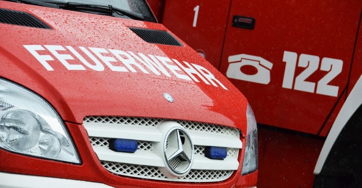 Ein Feuerwehrauto von vorne, darauf die Notrufnummer 122.