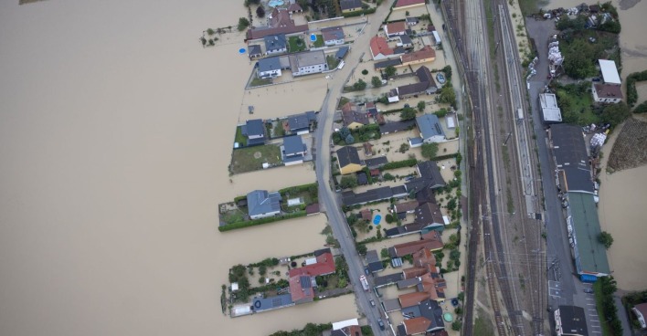 Luftaufnahme: eine Ortschaft in Niederösterreich steht vollständig unter Wasser, Häuser und einzelne Straßen ragen noch aus den schlammigen Fluten