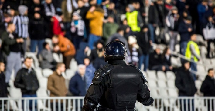 Polizist in voller Montur auf Fußballplatz