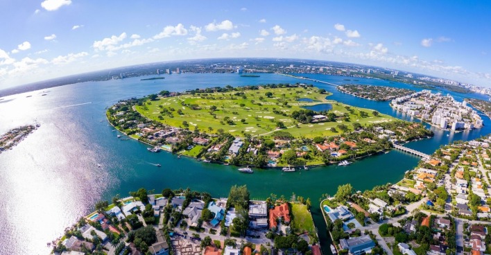 Insel mit Park und Häusern, drumherum Meer und darüber Himmel