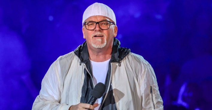 DJ Özi steht auf der Bühne mit Mikro in der Hand